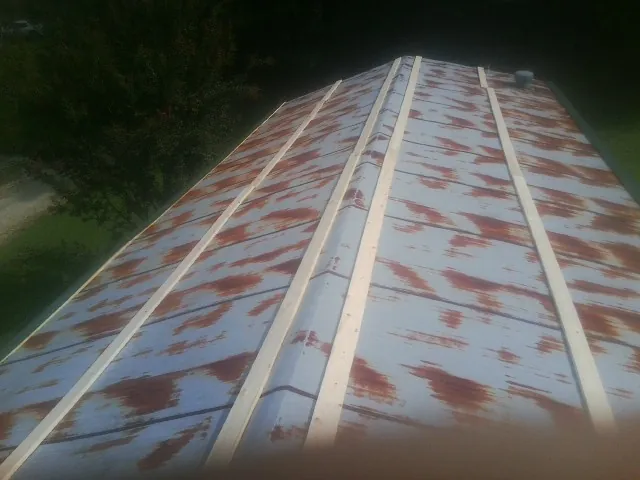 Rusted metal roof panels with new wood purlins before replacement — Storm Damage Roof Repair in Augusta by Roofing Brothers